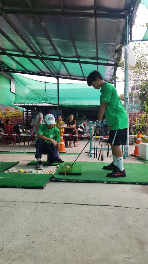 Huấn luyện viên hướng dẫn bé tập golf
